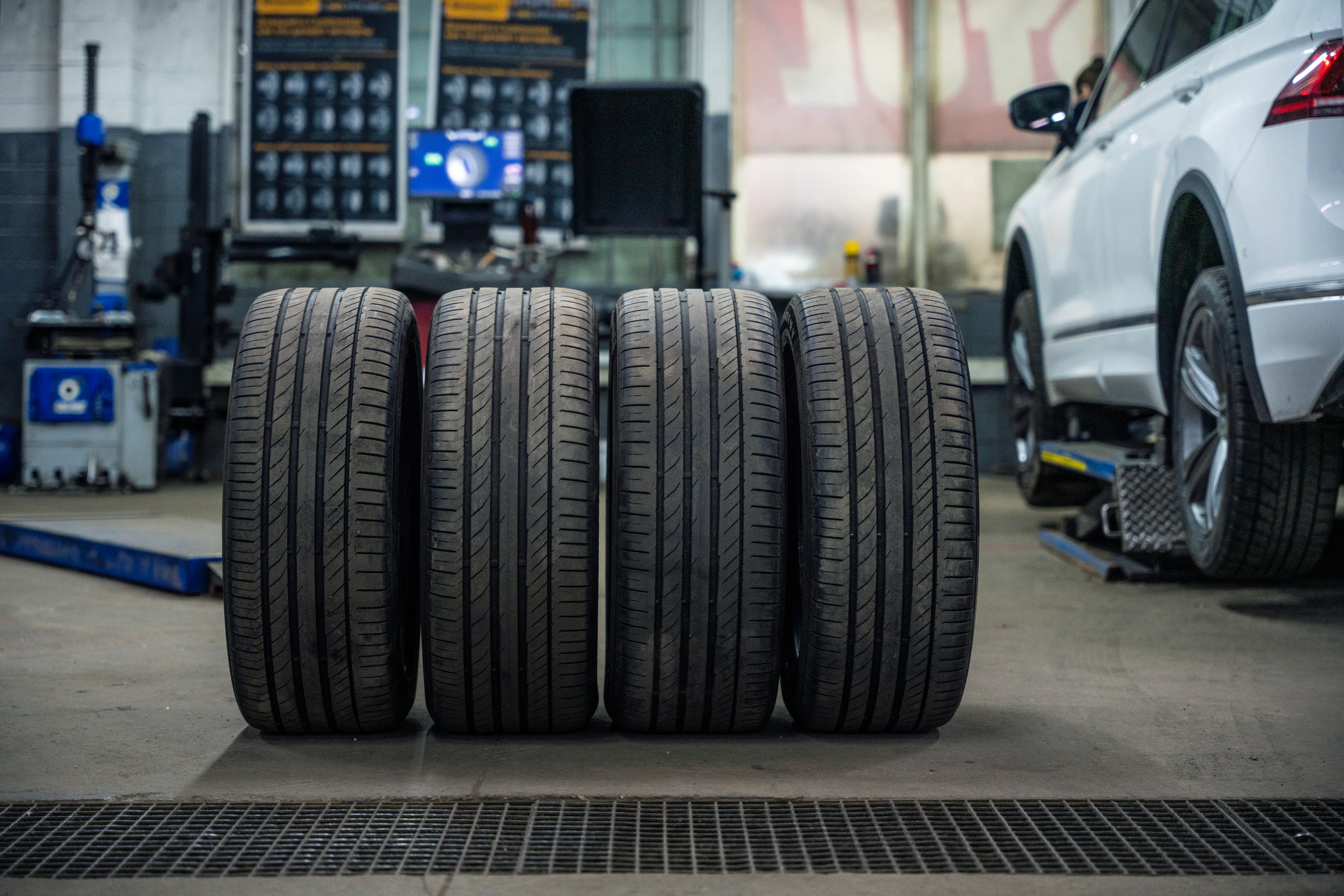 Set Of Used And Dirty Summer Tires At Tire Service And Car On A Lift